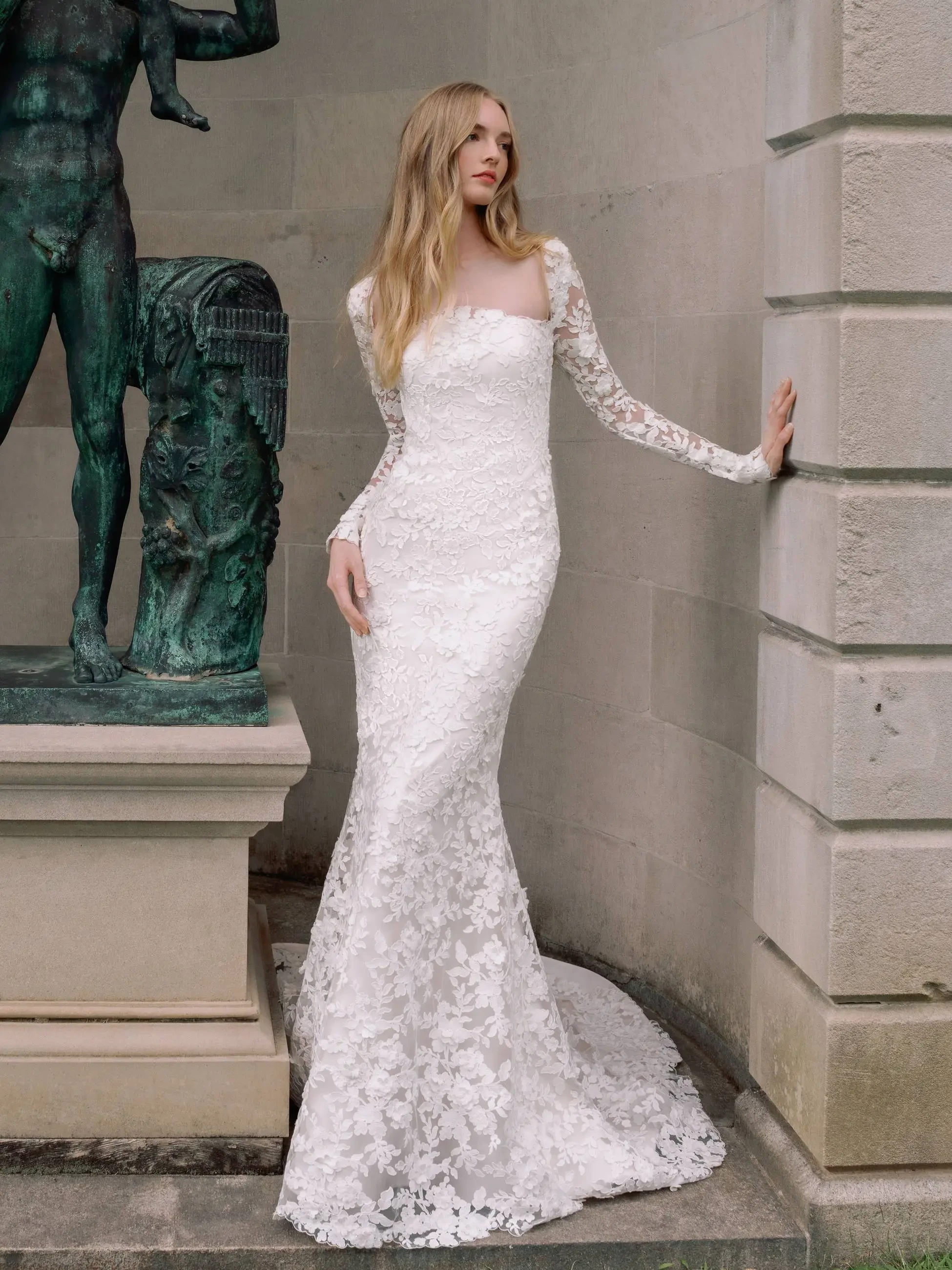 Model is wearing a square neckline fit and flare wedding dress