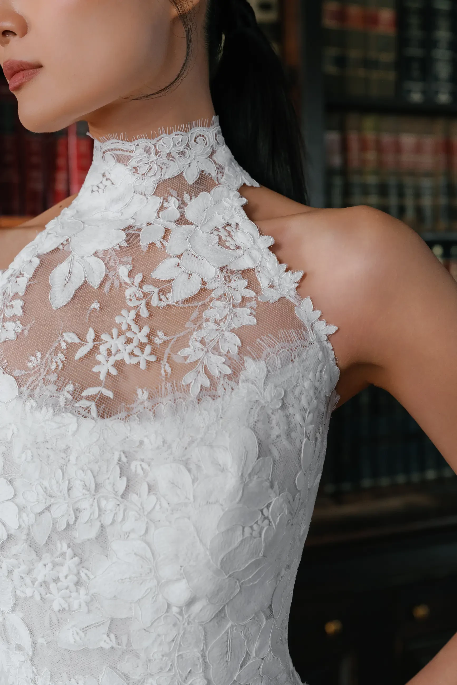 model is wearing a sleeveless high neckline lace wedding dress