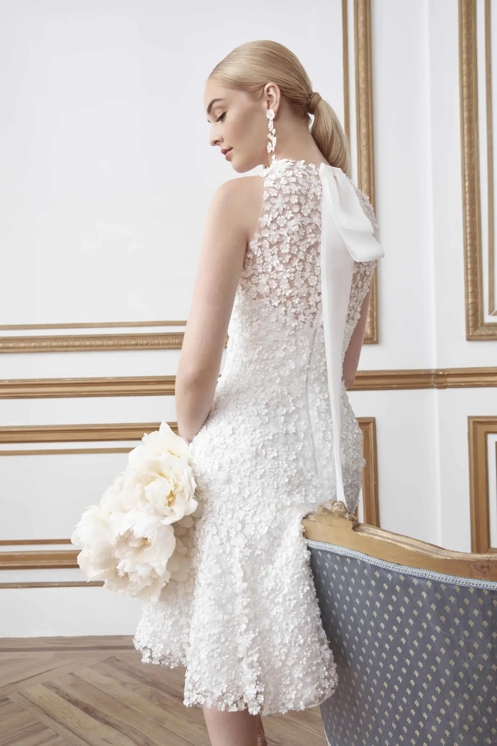 model is wearing a high neck sleeveless bridal gown