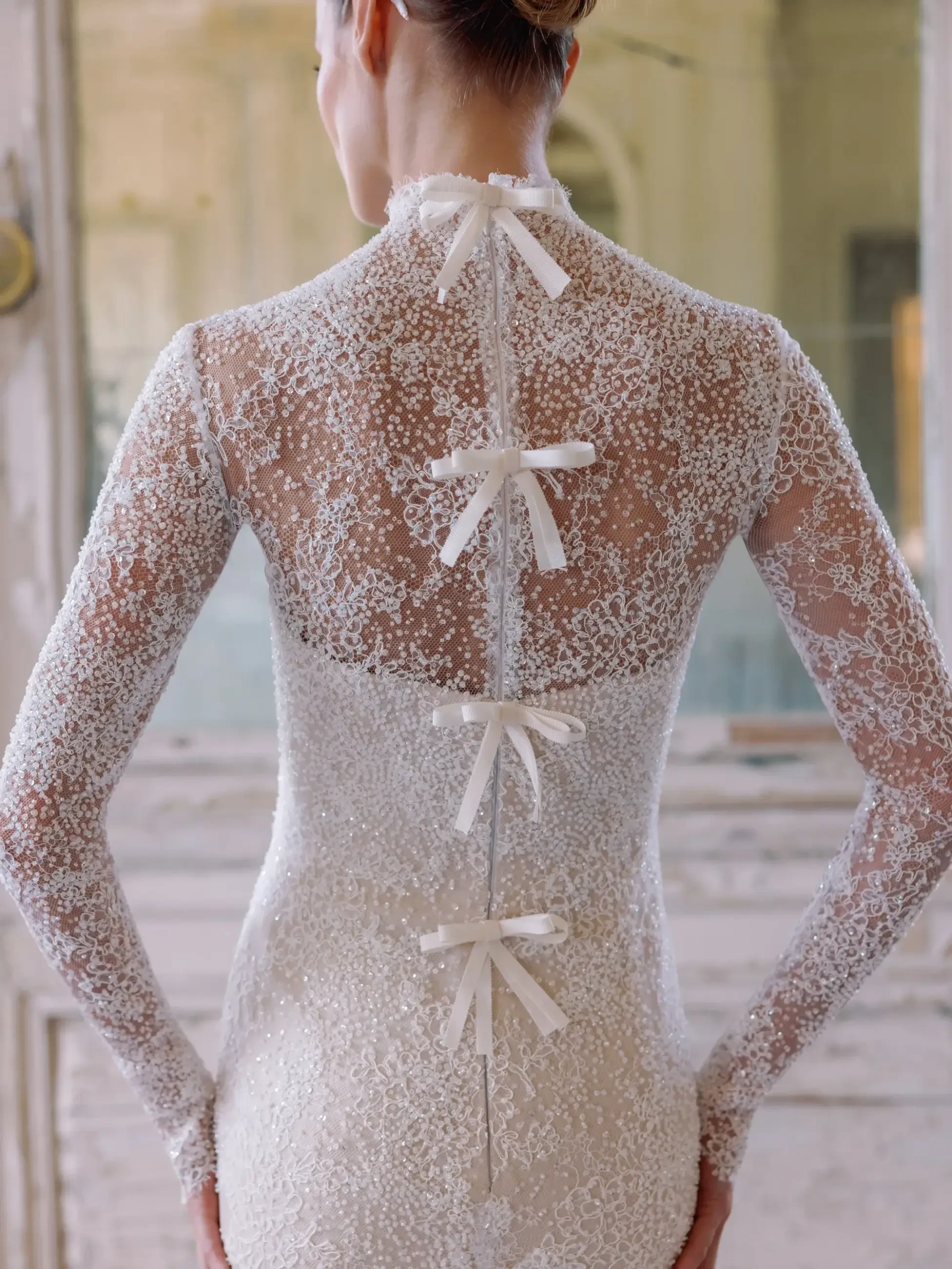 model wears a high neck long sleeve mini bridal gown