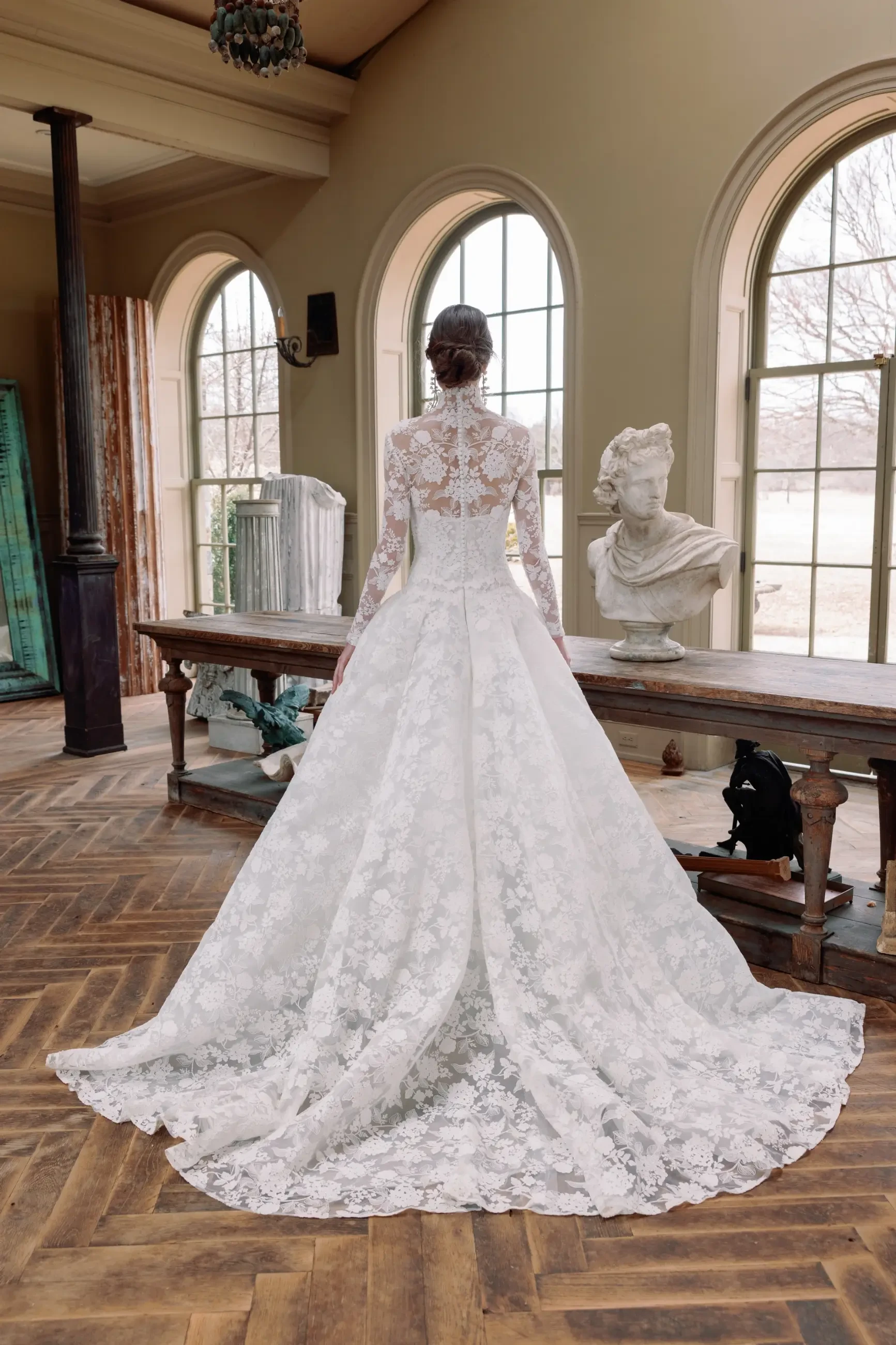 Model is wearing a floral ball gown wedding dress with a cat eye neckline and drop waist