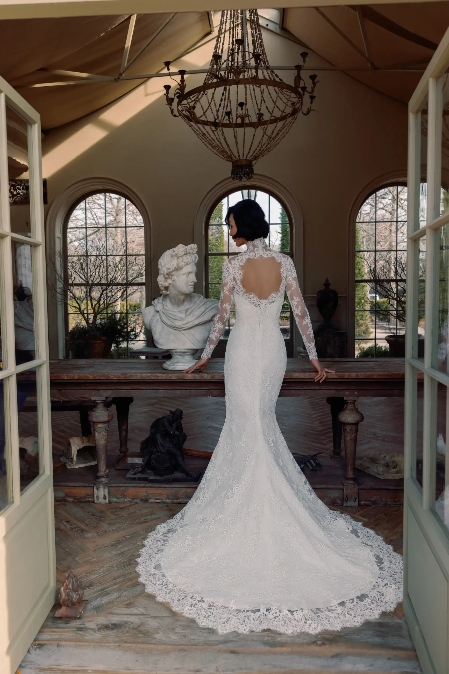 Model is wearing a fit and flare wedding dress with a sweetheart neckline and scalloped edging 
