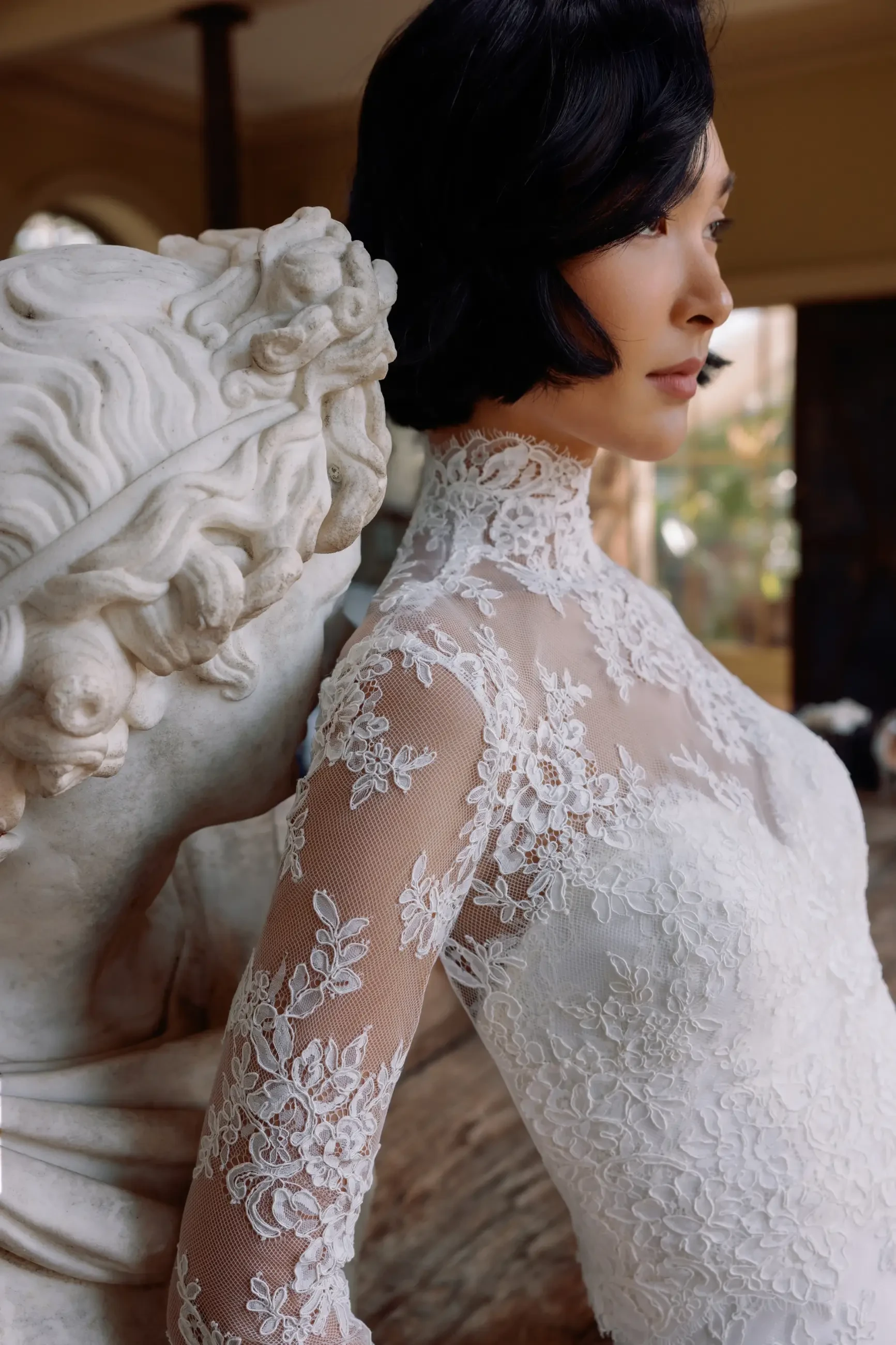 Model is wearing a fit and flare wedding dress with a sweetheart neckline and scalloped edging 