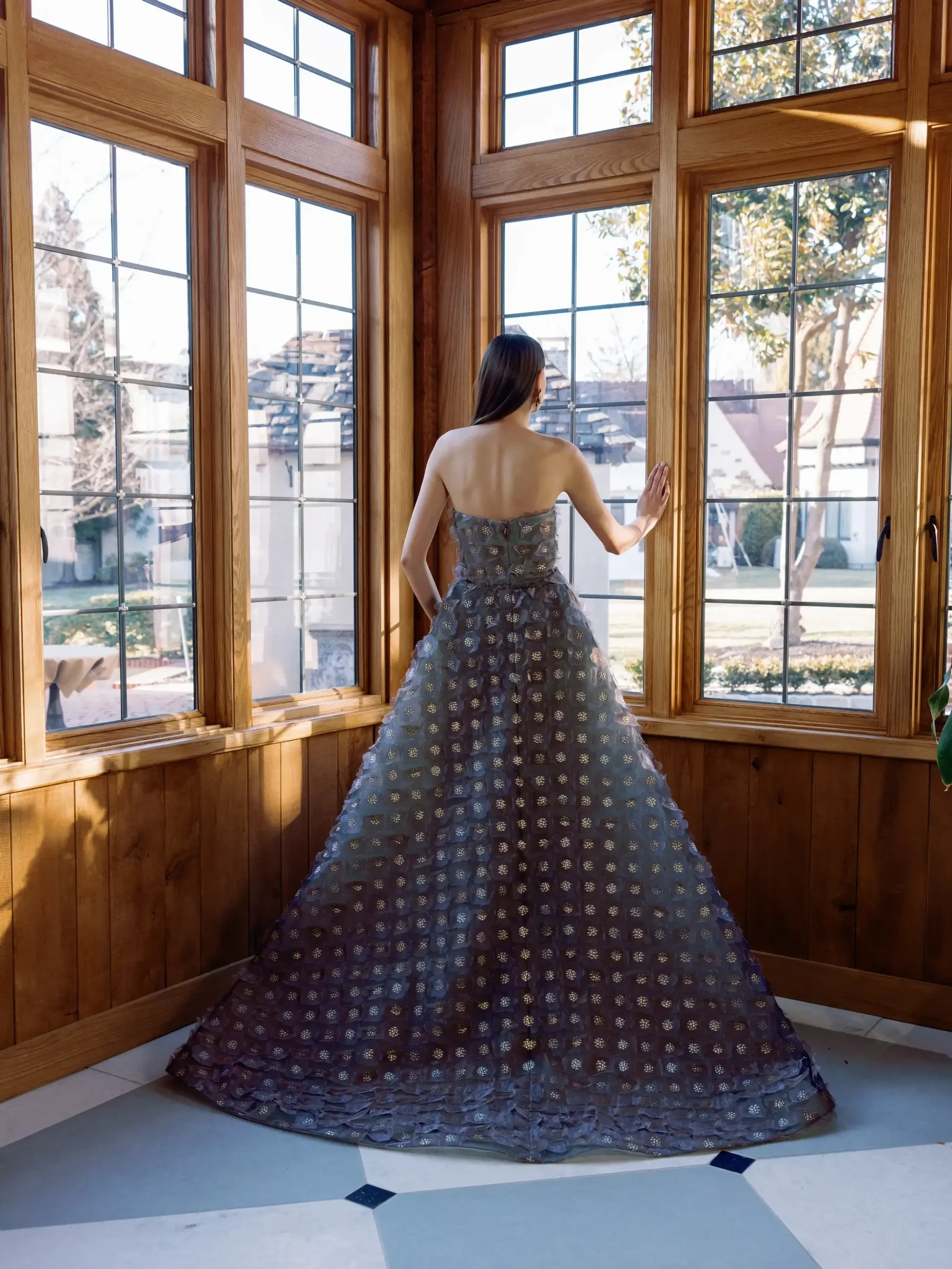 Model is wearing a printed organza column evening gown by Sareh Nouri