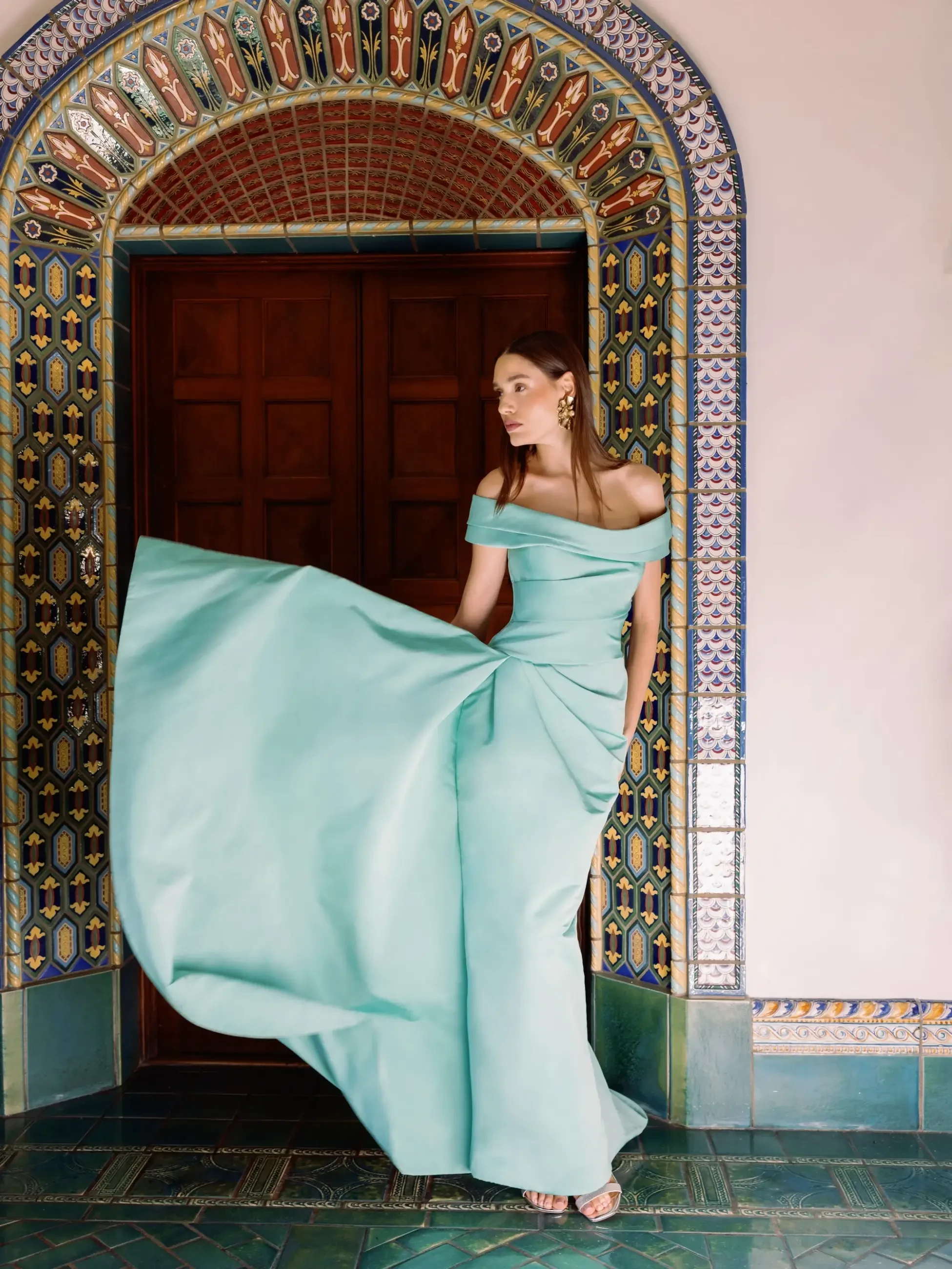 model wears a light blue off the shoulder evening gown