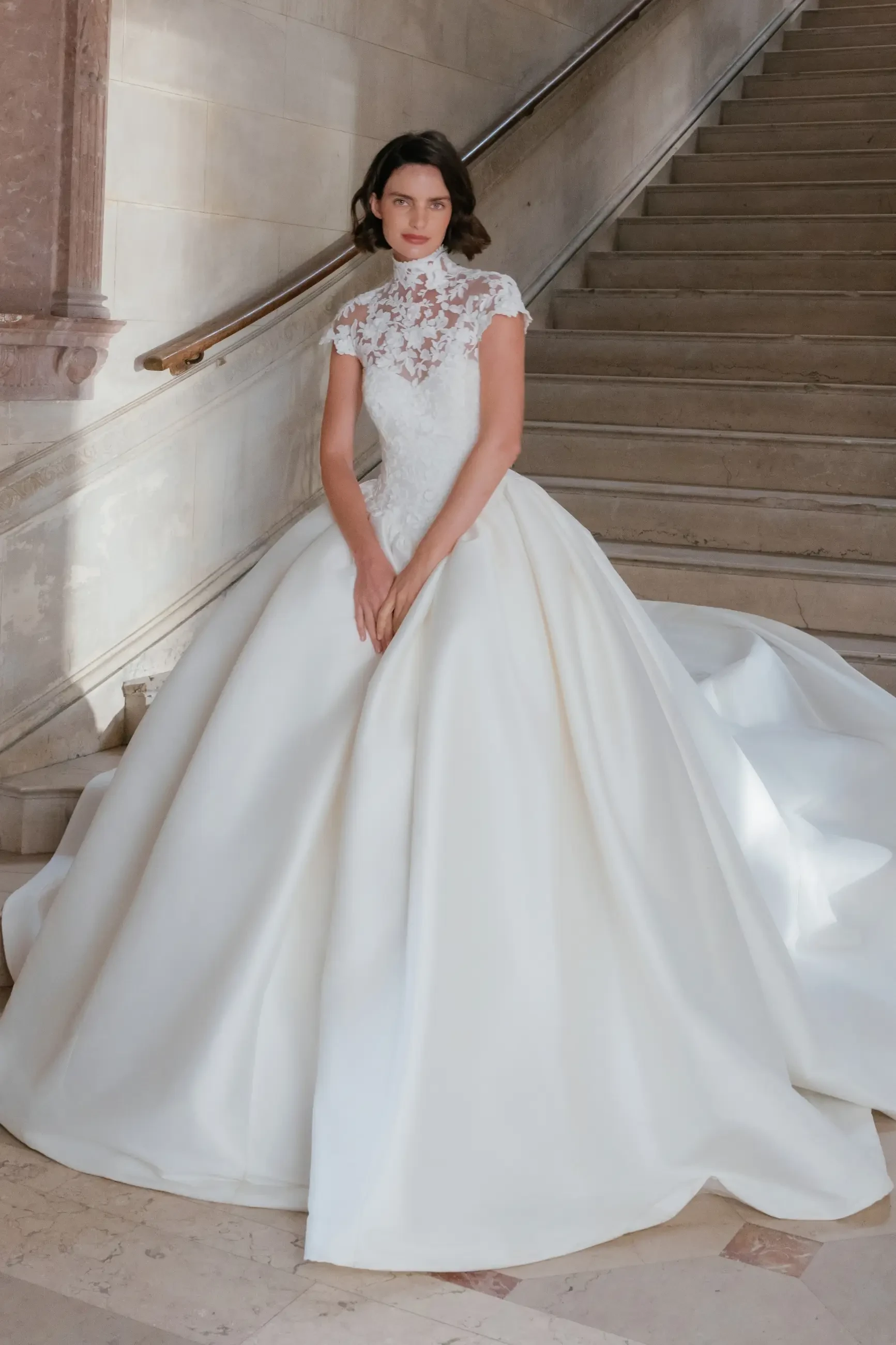 model is wearing a cap sleeve lace wedding gown