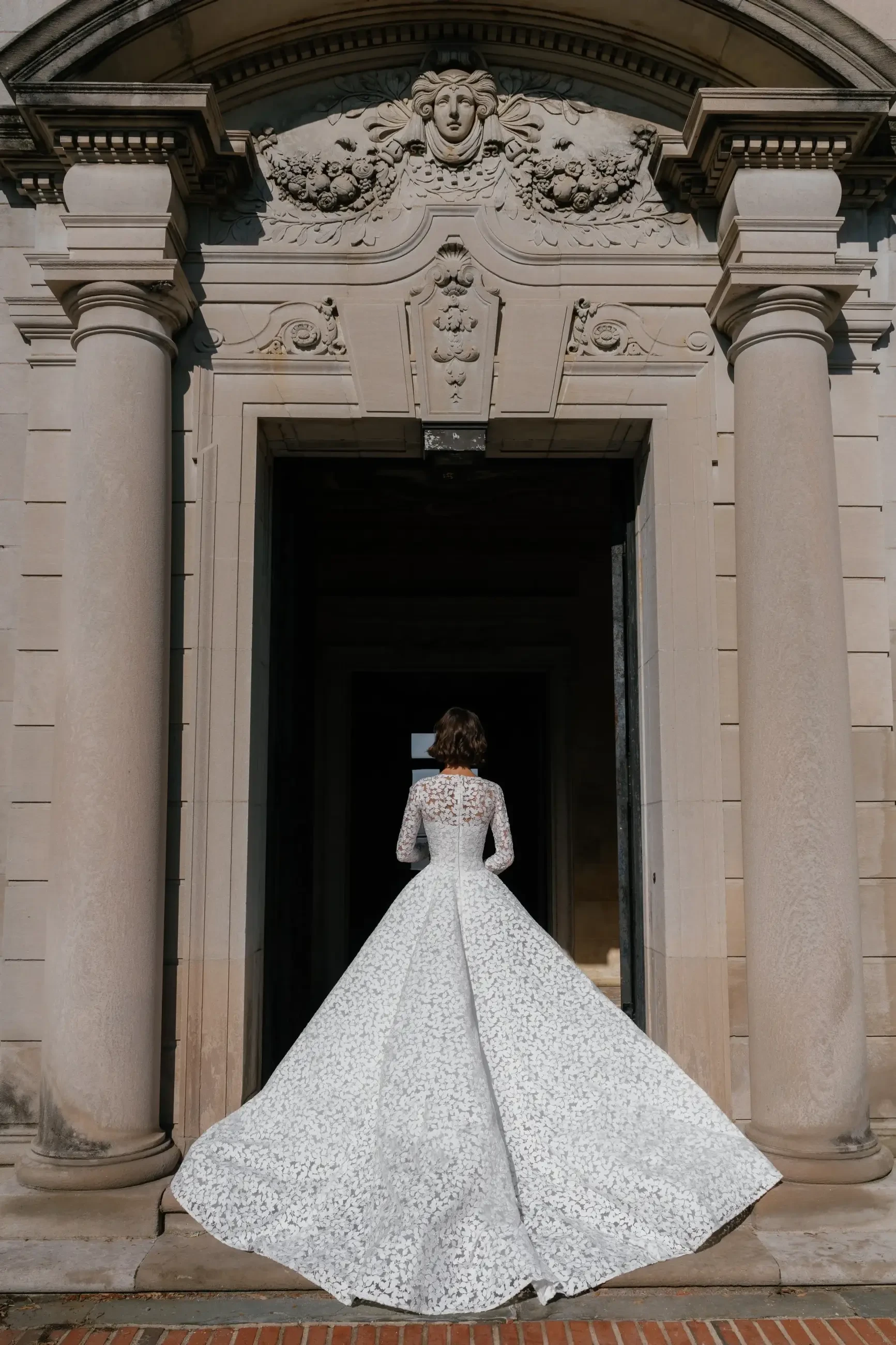 model is wearing a lace long sleeve ball gown wedding dress