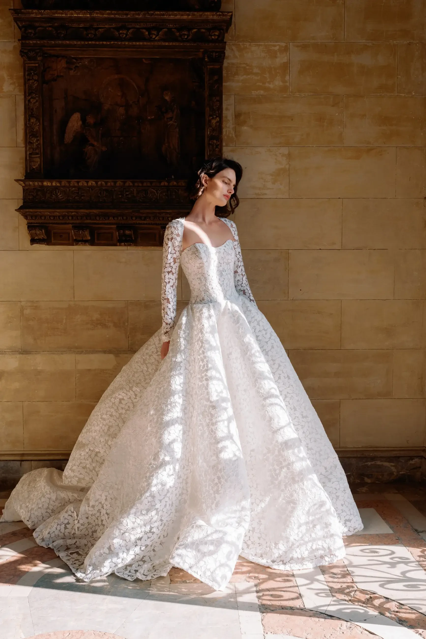 model is wearing a lace long sleeve bridal gown