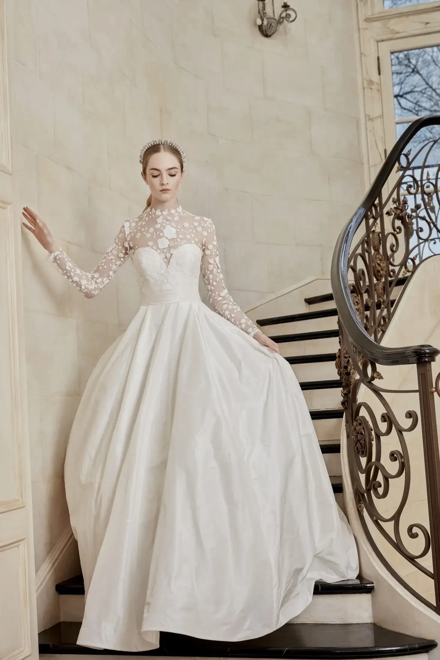 model is wearing a high neckline long sleeve wedding gown