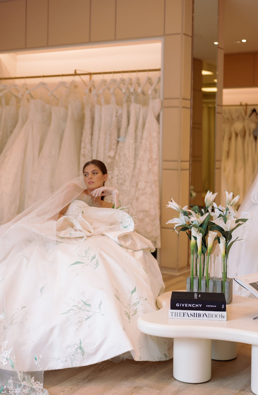 model is sitting in a chair wearing a wedding dress by sareh nouri in new york