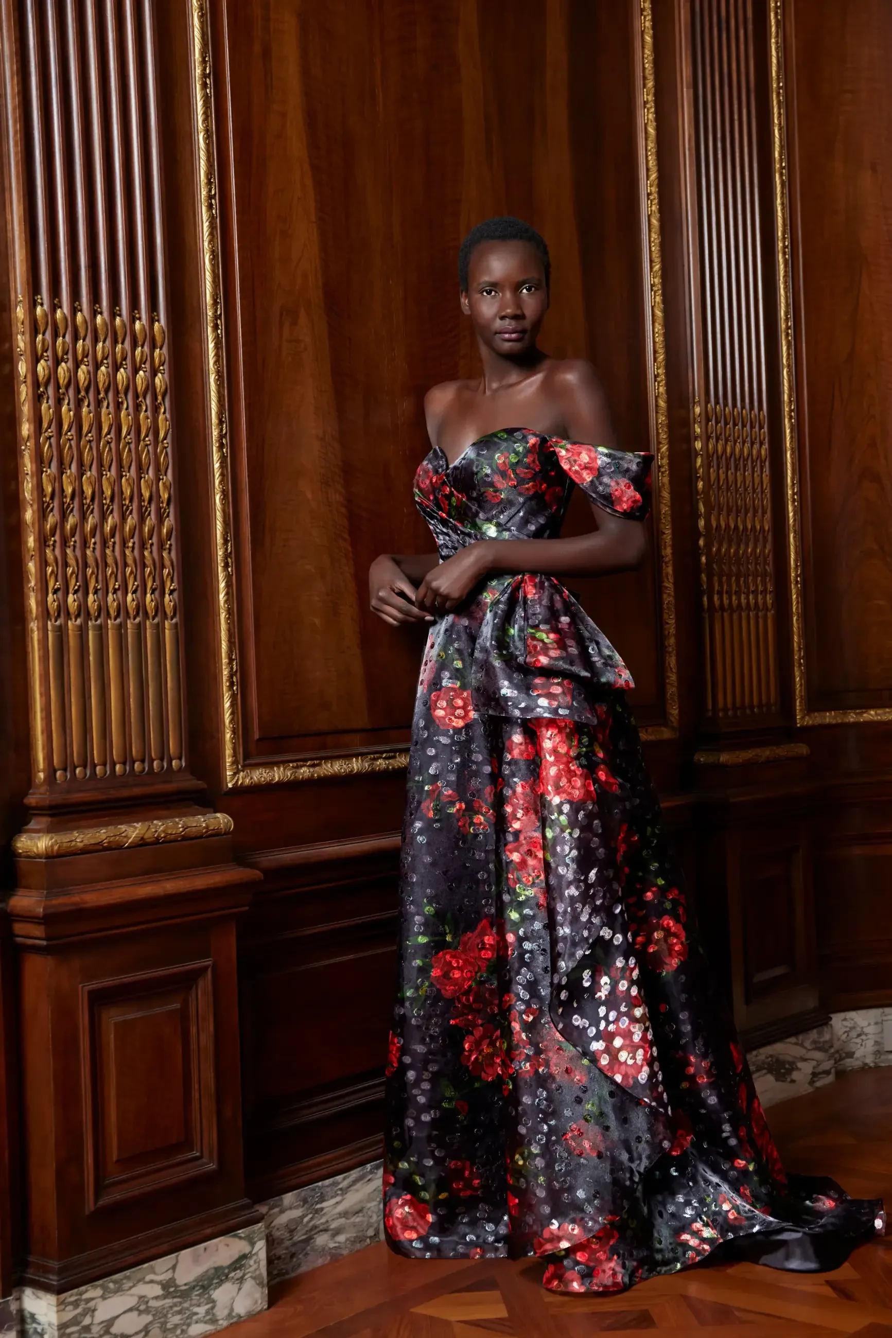 Model is wearing an off the shoulder floral print A-line evening gown by sareh nouri