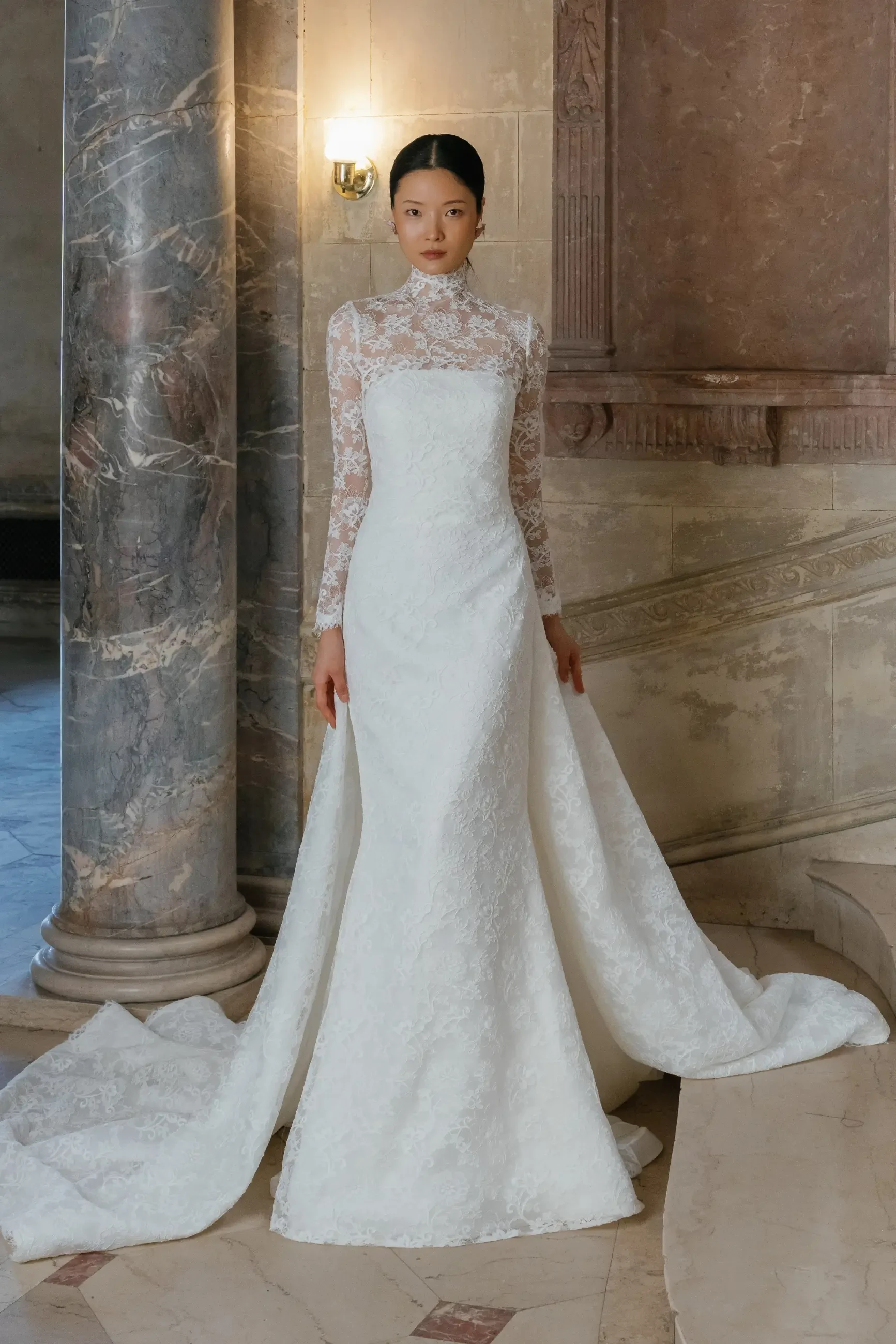 model is wearing a long sleeve lace wedding dress
