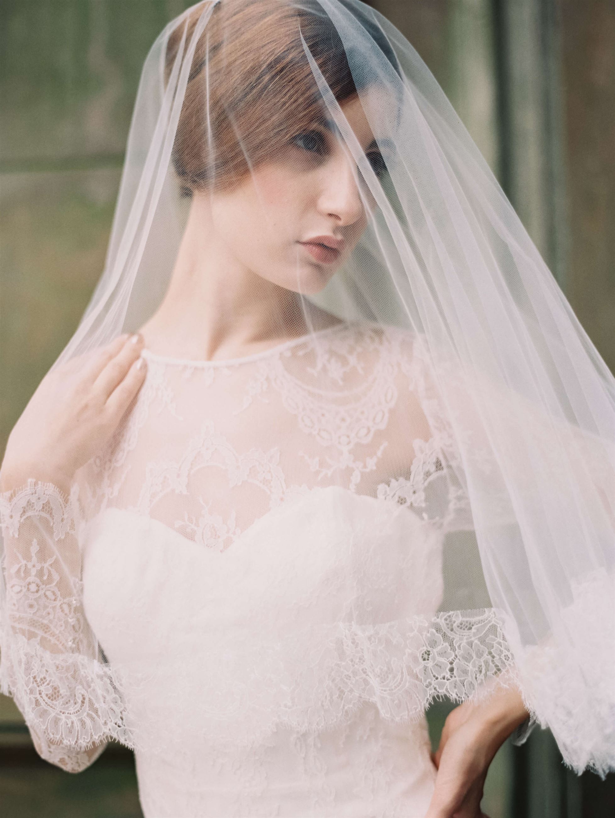Photo of the posing model wearing white bridal gown under the veil