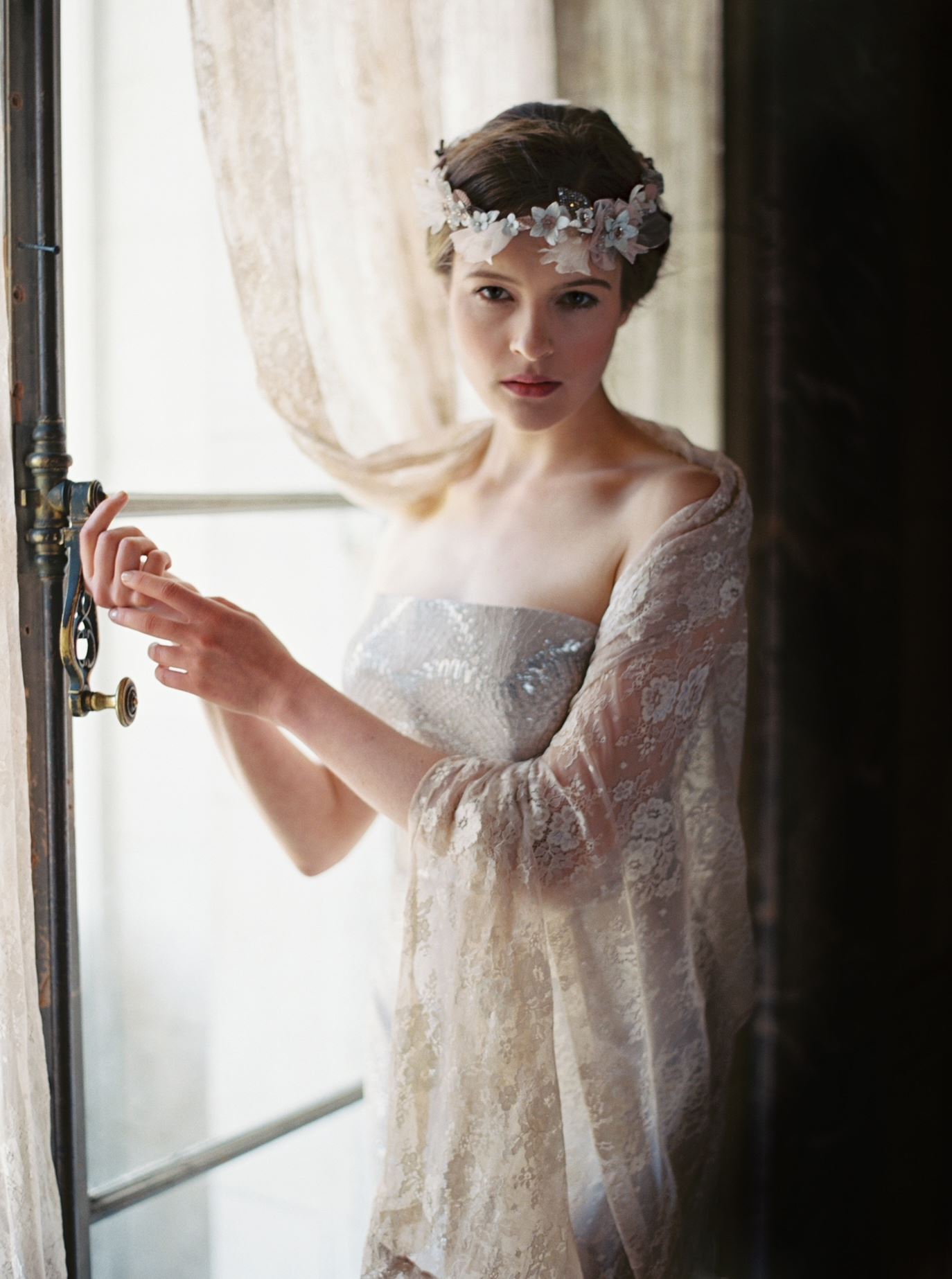 Model wearing a bridal gown near the window