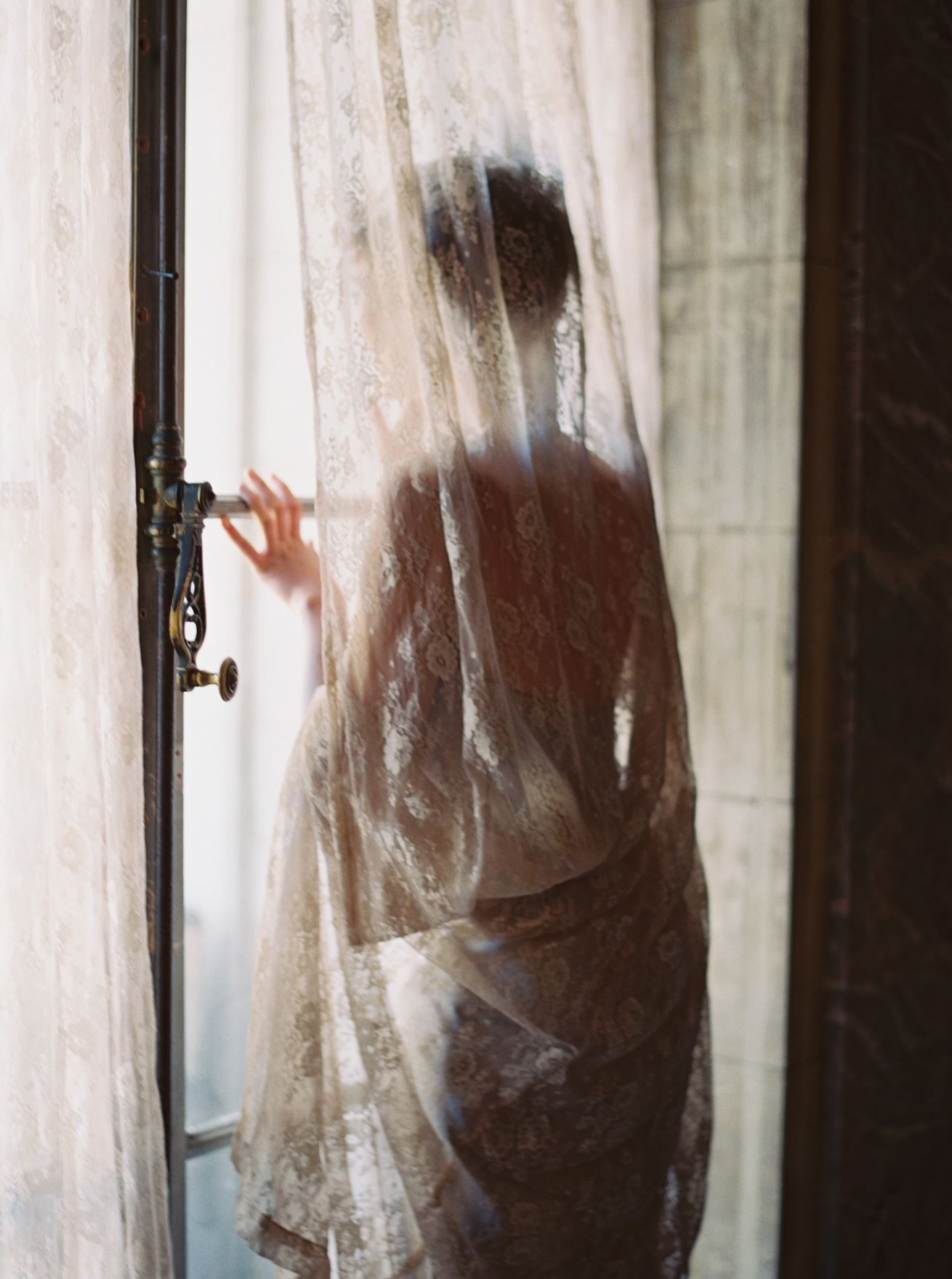 Photo of the model wearing white bridal gown near the window