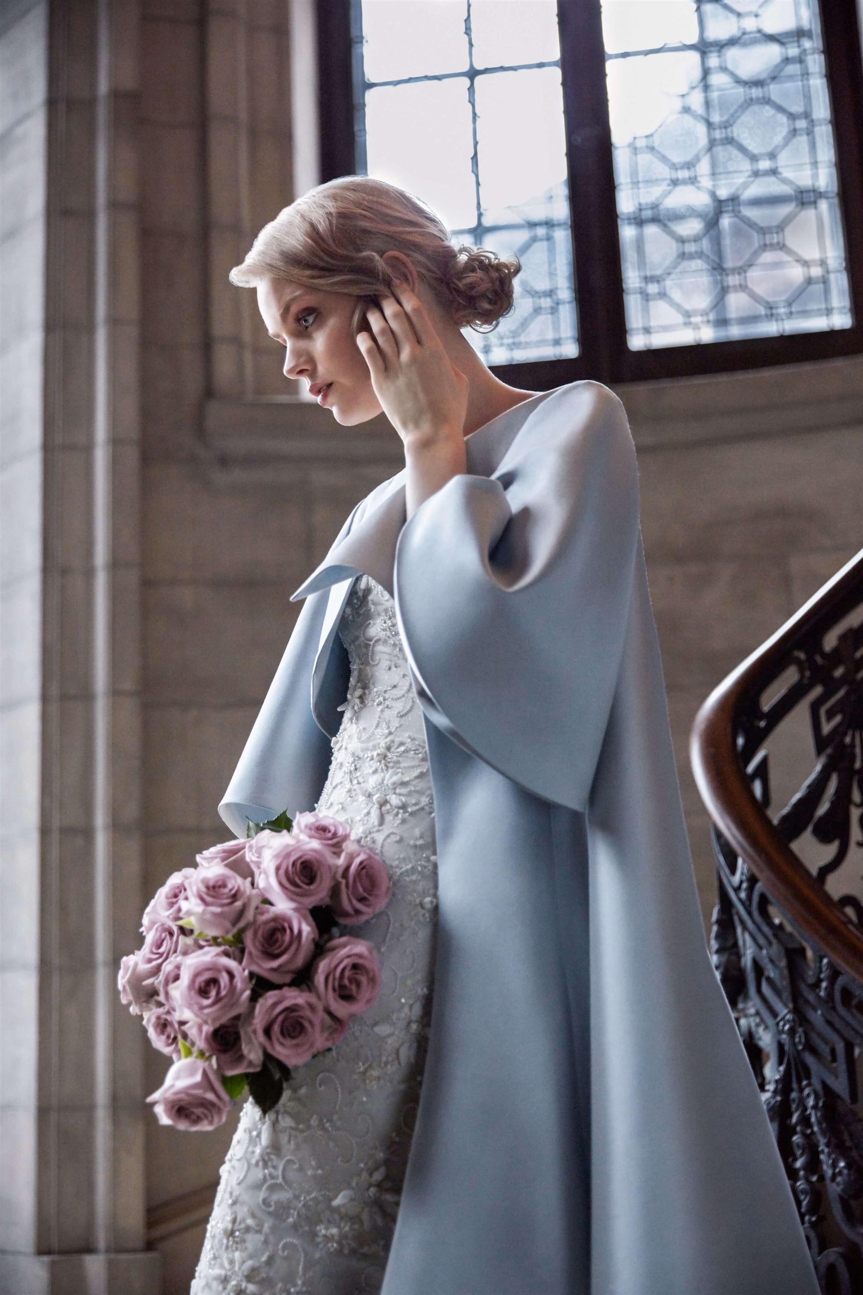 Model wearing a bridal gown with a bouquet